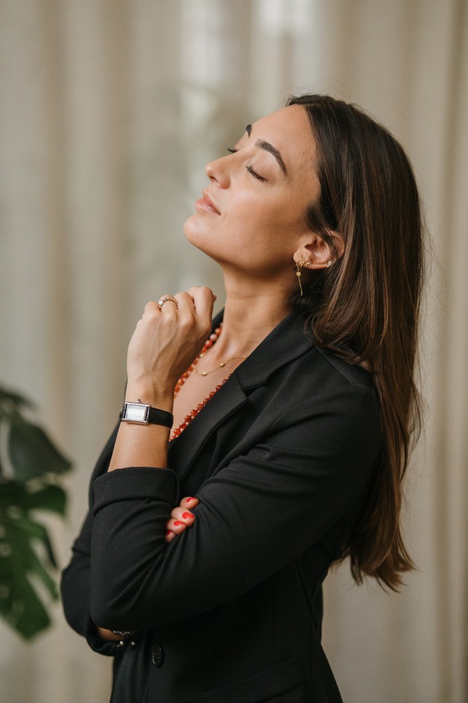 Júlia Sans with her eyes closed, one hand resting at her chest.